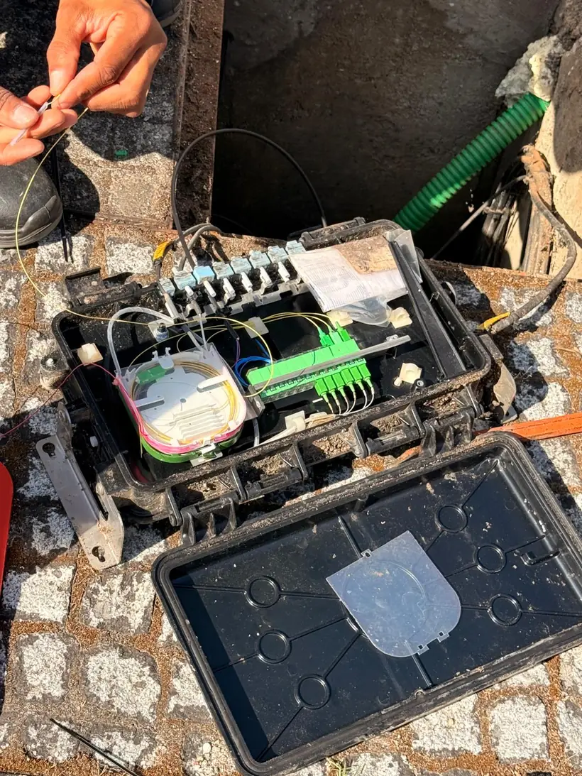 Trabalhos de instalação de fibra ótica numa caixa de rede
